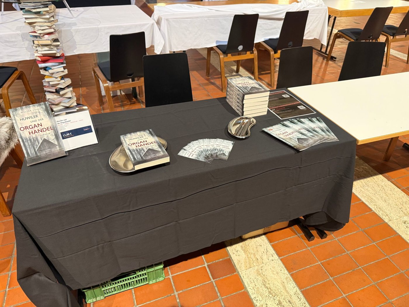 Tisch 25 an der Buchmesse Blätterrascheln: dunkle Tischdecke, Buchständer, Bücher, zwei Nierenschalen, Lesezeichen und Flyer